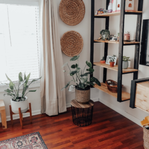 image of richly colored wood flooring with earthy elements and plants among black stained shelf brackets and woven wall baskets for Spring cleaning inspiration